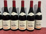 six bottles of wine are lined up on a table