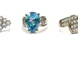 five different rings with blue stones on them on a white surface