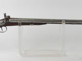 un vieux fusil au canon en bois, posé sur un socle transparent