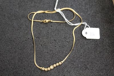 gros plan sur un collier en or portant une étiquette