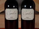 two bottles of wine sitting next to each other on a table