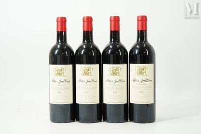 trois bouteilles de vin rouge sont alignées sur une surface blanche