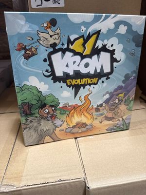 La boîte du jeu « Mom Evolution » est posée sur une boîte en carton.