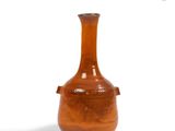 a brown vase that is sitting on a white surface
