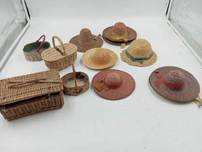 beaucoup de chapeaux de paille et un panier sur la table