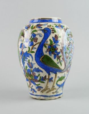 a blue and white vase with a peacock on it