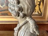 a statue of a boy with a hat on a wooden table