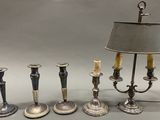 five candles that are sitting next to a lamp on a table