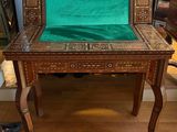 a man standing next to a table with a green cloth on it