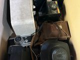 une boîte remplie de vieux appareils photo et d'autres appareils électroniques