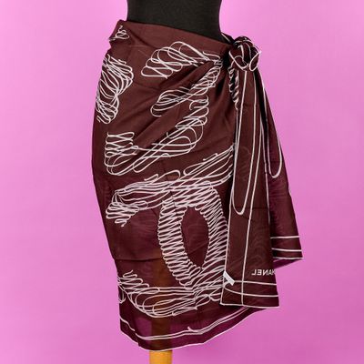 une femme portant une écharpe marron et blanche, posée sur un mannequin