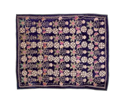 un tapis bleu et rose orné de fleurs et de feuilles