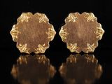 une paire de boucles d'oreilles en or sur une surface noire