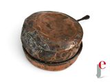a small copper pot with a handle on a white surface