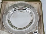 a silver plate and spoon in a box on a table
