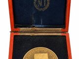 un gros plan d'une pièce d'or dans un écrin rouge
