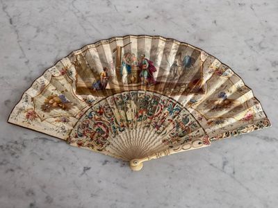 an old fan with a painting on it sitting on a table