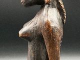 statue of a woman with a basket on her head sitting on a stool