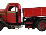 un camion rouge garé sur une surface blanche