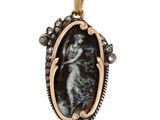 un pendentif noir et doré représentant une femme en robe