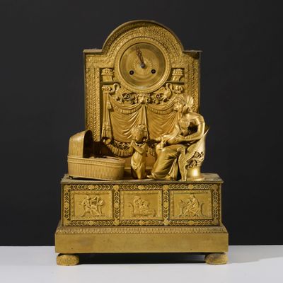 a gold clock sitting on top of a wooden table