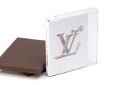 louis vu book with a box of chocolates on a white surface