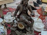 une statue représentant un homme assis sur une table