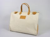 un sac en toile blanche avec des anses en cuir beige sur fond blanc