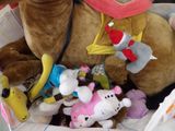 de nombreuses peluches rassemblées dans un panier posé par terre