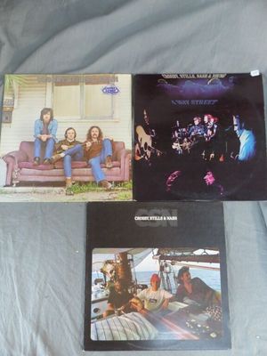 Trois albums du groupe The Eagles sont posés sur un lit