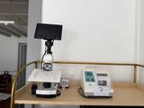 un bureau sur lequel se trouvent un ordinateur et un microscope