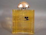 yellow bottle of perfume sitting on a white surface with a silver cap