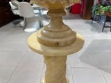 une statue représentant un oiseau, posée sur un socle au milieu d'une pièce