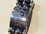 a silver watch with black beads on it and a price tag