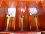 three wine glasses in a box with a green stem