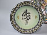 two plates with designs on them sitting next to each other