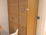 une chaise blanche placée devant une armoire en bois