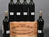 six bottles of red wine in a wooden crate on a table
