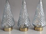 three clear glass christmas trees with gold bases on a white surface