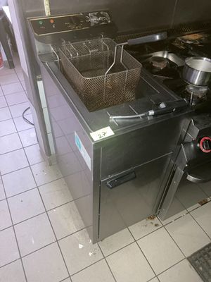 une photo d'une cuisine avec une cuisinière et une friteuse