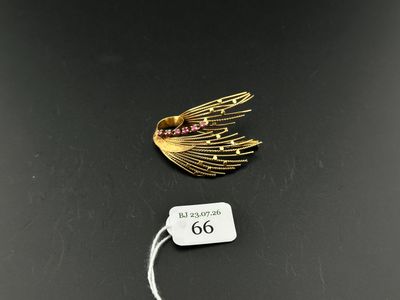 a close up of a gold plated brooch with a tag on it