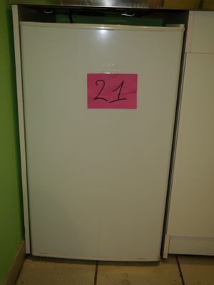 a white refrigerator with a pink sticker on it