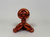 an orange balloon shaped like a man sitting on a table
