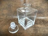 a small glass bottle and a small glass bottle on a table