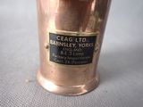 a small copper cup with a label on it