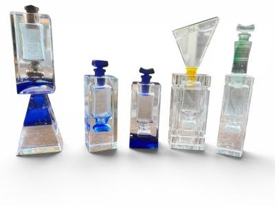 five different types of perfume bottles lined up on a white surface
