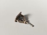 a small metal object that is on a white surface