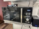 a microwave that is sitting on a shelf in a kitchen