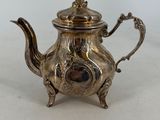 a silver tea pot with a handle and a handle on it