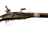 un vieux fusil exposé sur une surface blanche